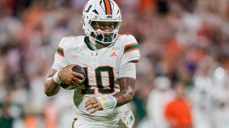 Miami quarterback Darian Mensah (10) runs with the ball in the first half of an NCAA college...