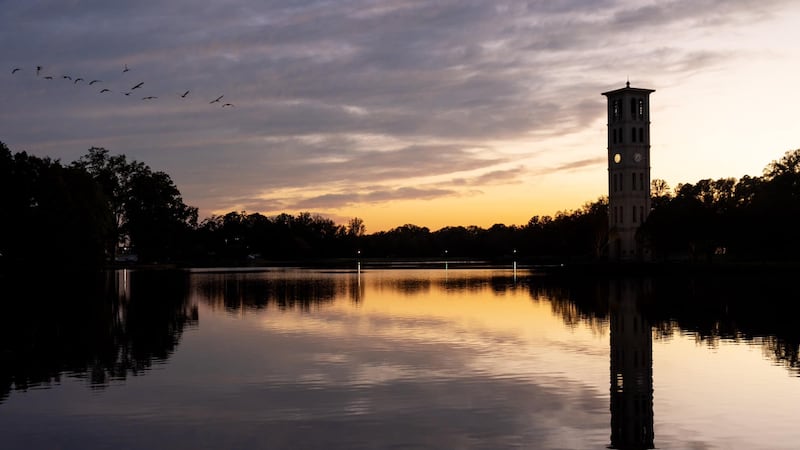 The sunset behind Furman Lake and the Bell Tower.