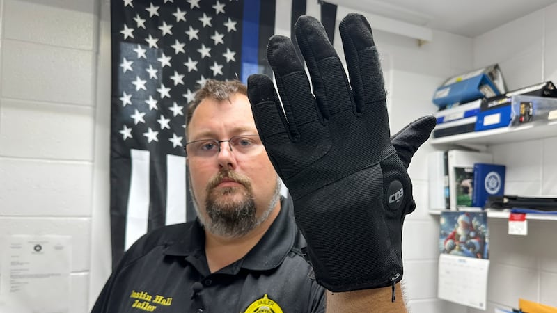 FILE - Nelson County, Ky., jailer Justin Hall shows an electric shock glove that is used at...
