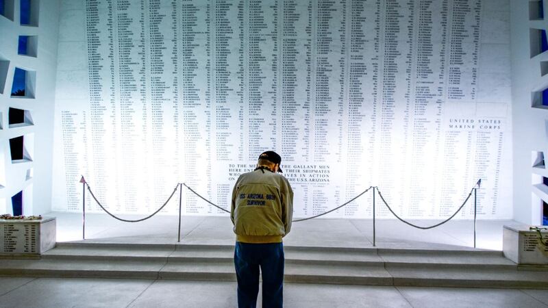 USS Arizona survivor Donald Stratton bows his head before the remembrance wall that lists the...